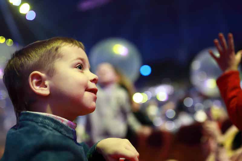 A young boy in a crowd symbolizes the future generations to which the common good applies in Catholic social teaching