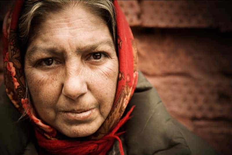 An elderly woman's face, wrapped in a scarf, calling to mind the Church's preferential option for the poor