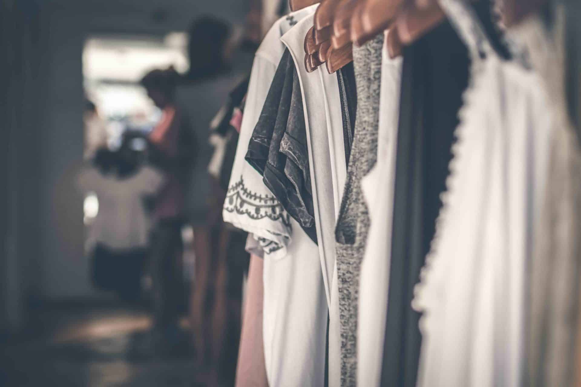 A row of blouses hanging on a rack, making us call into question whether our purchasing habits contribute to consumerism